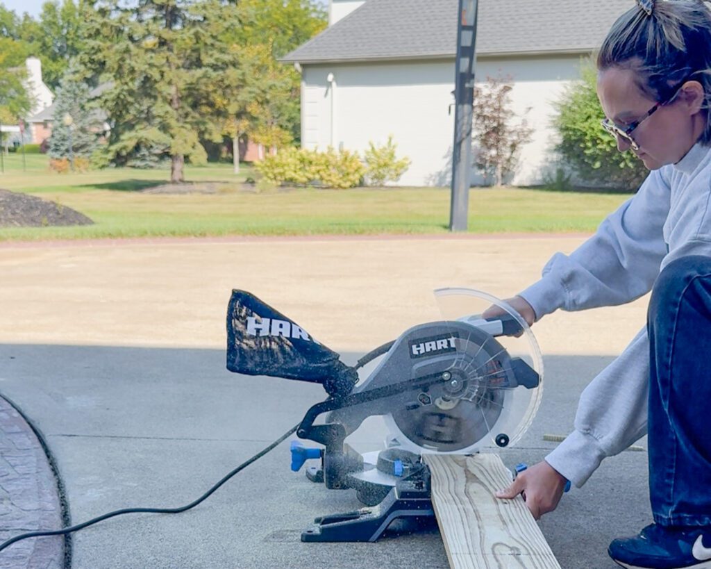 Using the miter saw to trim off the edges of the pressure treated lumber.